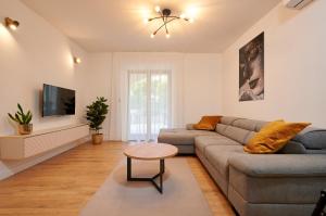 ein Wohnzimmer mit einem Sofa und einem TV in der Unterkunft Apartment Natali - 5 M from the beach in Trogir
