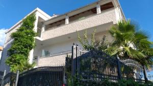 una casa blanca con una puerta negra y una palmera en Villa Mira Trogir, en Trogir
