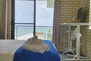 a teddy bear sitting on a bed in a bedroom at Ocean view beachside 3 bedroom 2 bathroom unit in Caloundra