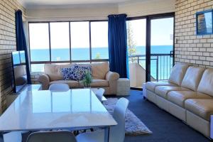 a living room with a couch and a table at Ocean view beachside 3 bedroom 2 bathroom unit in Caloundra