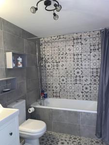 La salle de bains est pourvue d'une baignoire, de toilettes et d'un lavabo. dans l'établissement Maison Familiale centre Dijon, à Dijon