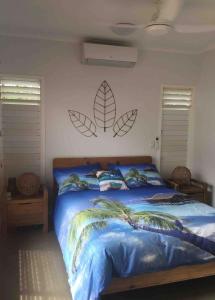a bedroom with a bed with leaves on the wall at Home in mission beach in Mission Beach