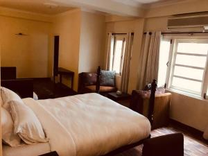 Een bed of bedden in een kamer bij Courtyard Pujan Hotel