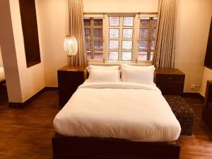 Een bed of bedden in een kamer bij Courtyard Pujan Hotel