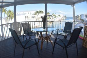 einen Tisch und Stühle auf einem Balkon mit Wasser in der Unterkunft Pelican's Roost, Waterfront comfort at Venture Out in Cudjoe Key