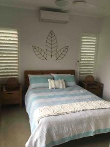 a bedroom with a large bed with leaves on the wall at Home in mission beach in Mission Beach