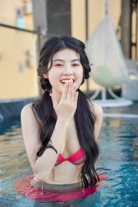 a woman in the water in a swimming pool at Sea Wind Hotel by THG in Da Nang
