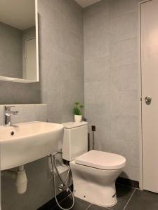 a bathroom with a white toilet and a sink at KEEN Suites-Jesselton Quay in Kota Kinabalu