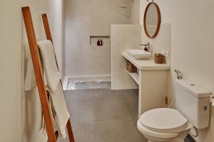 a white bathroom with a toilet and a sink at New Villa La Crema - Designer 3BR Canggu in Canggu