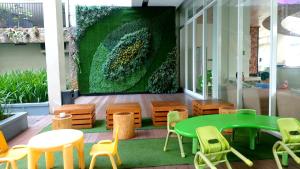a room with a green table and chairs and a wall at Apartement Bogor Icon Syariah, View Gunung Salak in Bogor