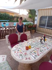uma mulher ao lado de uma mesa com uma toalha de mesa em Tara Casa Rural em Cartagena