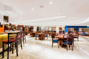 a dining room with wooden tables and chairs at Sheraton Guayaquil in Guayaquil