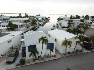 Cudjoe KeyにあるPelican's Roost, Waterfront comfort at Venture Outの家屋やヤシの木が植えられた港の空中風景