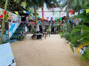 um pátio com bandeiras e mesas e bancos num edifício em Star Rest Beach Hotel em Baía de Arugam