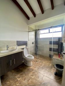 a bathroom with a toilet and a sink and a shower at Finca en Marinilla in Marinilla