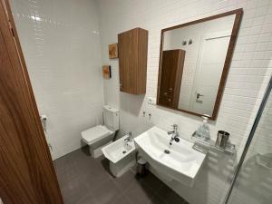 uma casa de banho com um lavatório, um WC e um espelho. em La Fortaleza em Baños de la Encina