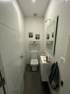 een witte badkamer met een toilet en een wastafel bij La Fortaleza in Baños de la Encina
