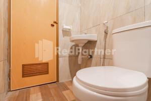 a bathroom with a white toilet and a shower at D'Valley View Lembang Mitra RedDoorz in Lembang +39 photos