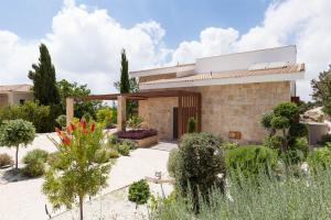 a house with a garden in front of it at Aphrodite Hills 4 bedroom villa with private infinity pool in Kouklia