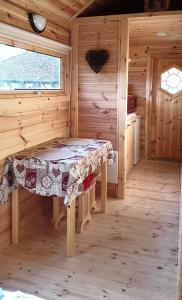 una habitación con una mesa en una cabaña de madera en White wood tiny house en Darney