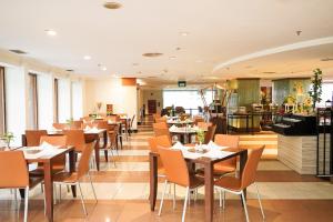 a restaurant with tables and chairs in a room at AP Premier Batam in Nagoya
