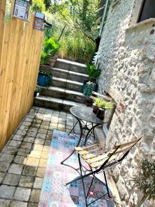 un patio con mesa, sillas y escaleras en Le Secret de Mélin, en Mélin