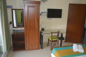 Schlafzimmer mit einem Bett und einem Schreibtisch mit einem Tisch in der Unterkunft Paramount Residence 3 in Kelaniya