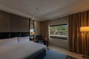 a hotel room with a bed and a window at PC Legacy Hunza in Hunza Valley