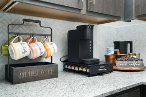 a kitchen counter with coffee cups and a stove at Zenful Affirmations Stay-cozy Wfhmins-medical Ctr in San Antonio