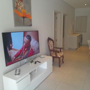 a living room with a large flat screen tv on a wall at Joli appartement neuf 2ch 2sdb 50m de la mer in Grand-Baie