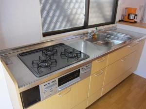 a kitchen with a stove and a sink at Cheese Cozy Condo in Tokyo