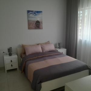 a bedroom with a bed and two night stands and a window at Joli appartement neuf 2ch 2sdb 50m de la mer in Grand-Baie