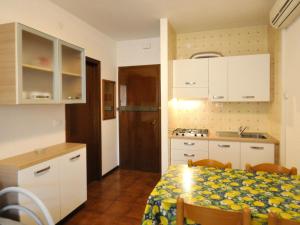 a kitchen with a table and a kitchen with white cabinets at Apartment in Bibione near Sea Beach in Bibione