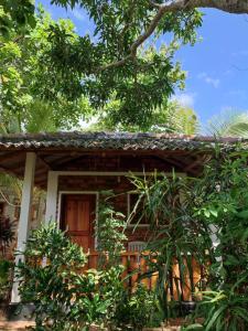 ein Haus inmitten eines Gartens mit Bäumen in der Unterkunft Isuru Cabanas and Restaurant in Tangalle