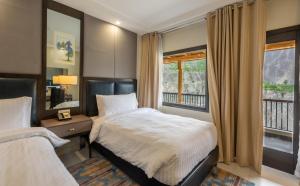 a bedroom with two beds and a window at PC Legacy Hunza in Hunza Valley