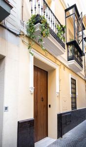 - un bâtiment avec une porte en bois dans une rue dans l'établissement EME SEVILLA TURISTICA, à Séville