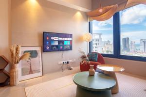 a living room with a tv and a chair and a table at Tropicana 218 X Airlevate Suites in George Town