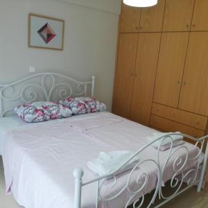 um quarto com uma cama branca e um armário de madeira em Fanari Apartment em Fanárion