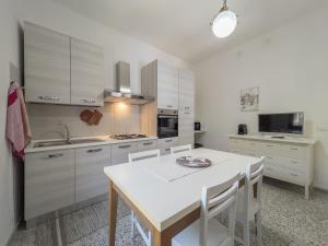 una cucina con armadi bianchi e tavolo bianco di [Casa Vacanze Mallela] • Balcony, A/C & SmartTv a Loceri