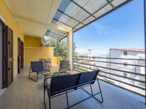 einen Balkon mit Stühlen, einem Tisch und Aussicht in der Unterkunft [Casa Vacanze Mallela] • Balcony, A/C & SmartTv in Loceri