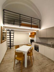eine Küche mit einem weißen Tisch und einigen Stühlen in der Unterkunft La Disfida Di Barletta in Barletta