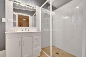 a white bathroom with a sink and a shower at Home Away From Home Little White Cottage Mudgee in Mudgee