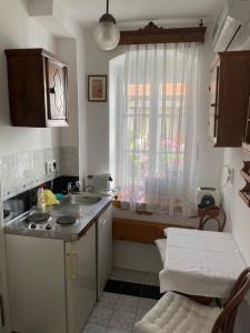 eine kleine Küche mit Spüle und Fenster in der Unterkunft Hajós-ház in Szeged