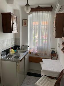 una pequeña cocina con fregadero y ventana en Hajós-ház en Szeged