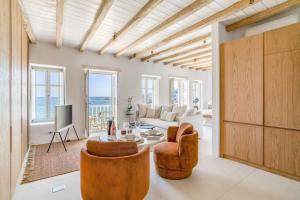 a living room with a couch and a table and chairs at Fotis House - Unique in Paros in Naousa