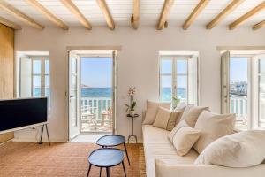 Una sala de estar con un sofá blanco y un televisor. en Fotis House - Unique in Paros, en Naousa