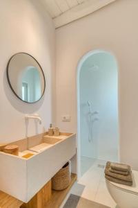 Un baño con lavabo, espejo e inodoro. en Fotis House - Unique in Paros, en Naousa