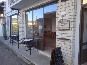 DolianaにあるThiamis Guesthouseの窓の外にテーブルと椅子があるレストラン