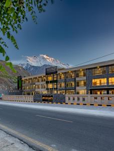 ein Gebäude an der Seite einer Straße mit einem Berg in der Unterkunft PC Legacy Hunza in Hunza