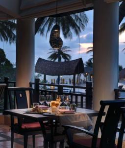 a table with food and wine glasses on a patio at Rawi Warin Resort And Spa - SHA Extra Plus in Ko Lanta